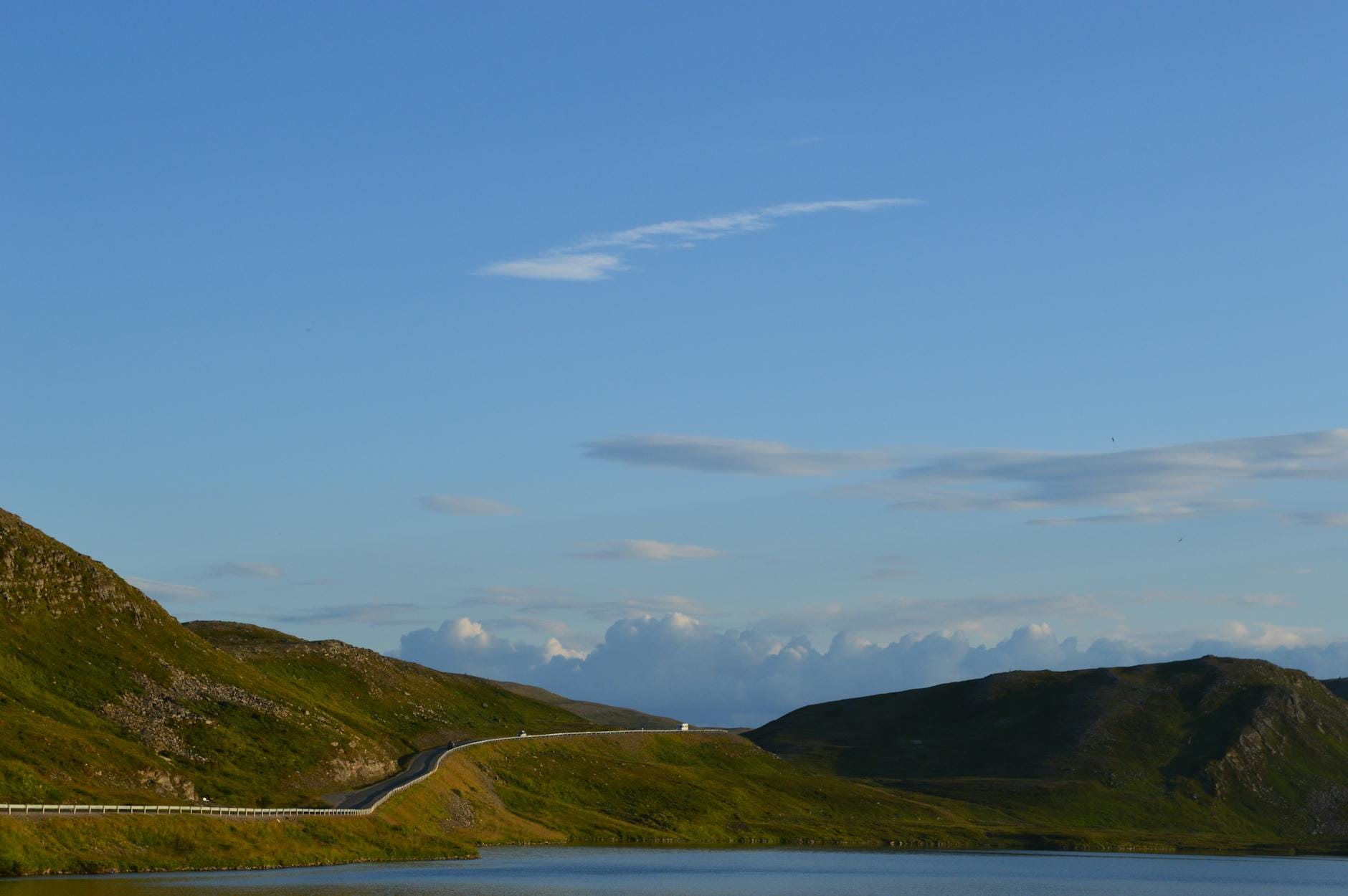 Kręta droga wśród łagodnych wzgórz Finnmarku o zmierzchu