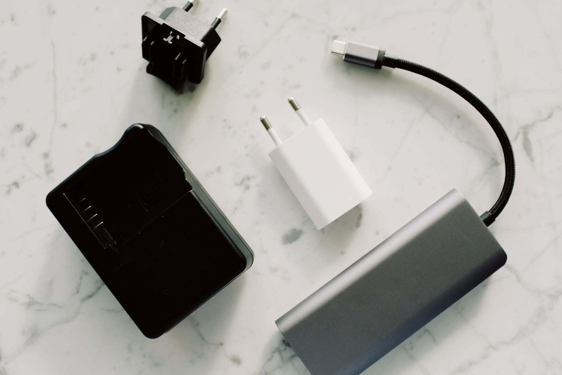 Adaptery i kable USB-C rozłożone na marmurowym blacie