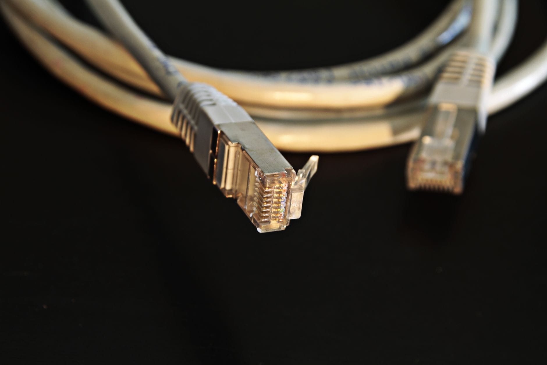 Zbliżenie na wtyczki kabla Ethernet na czarnym tle